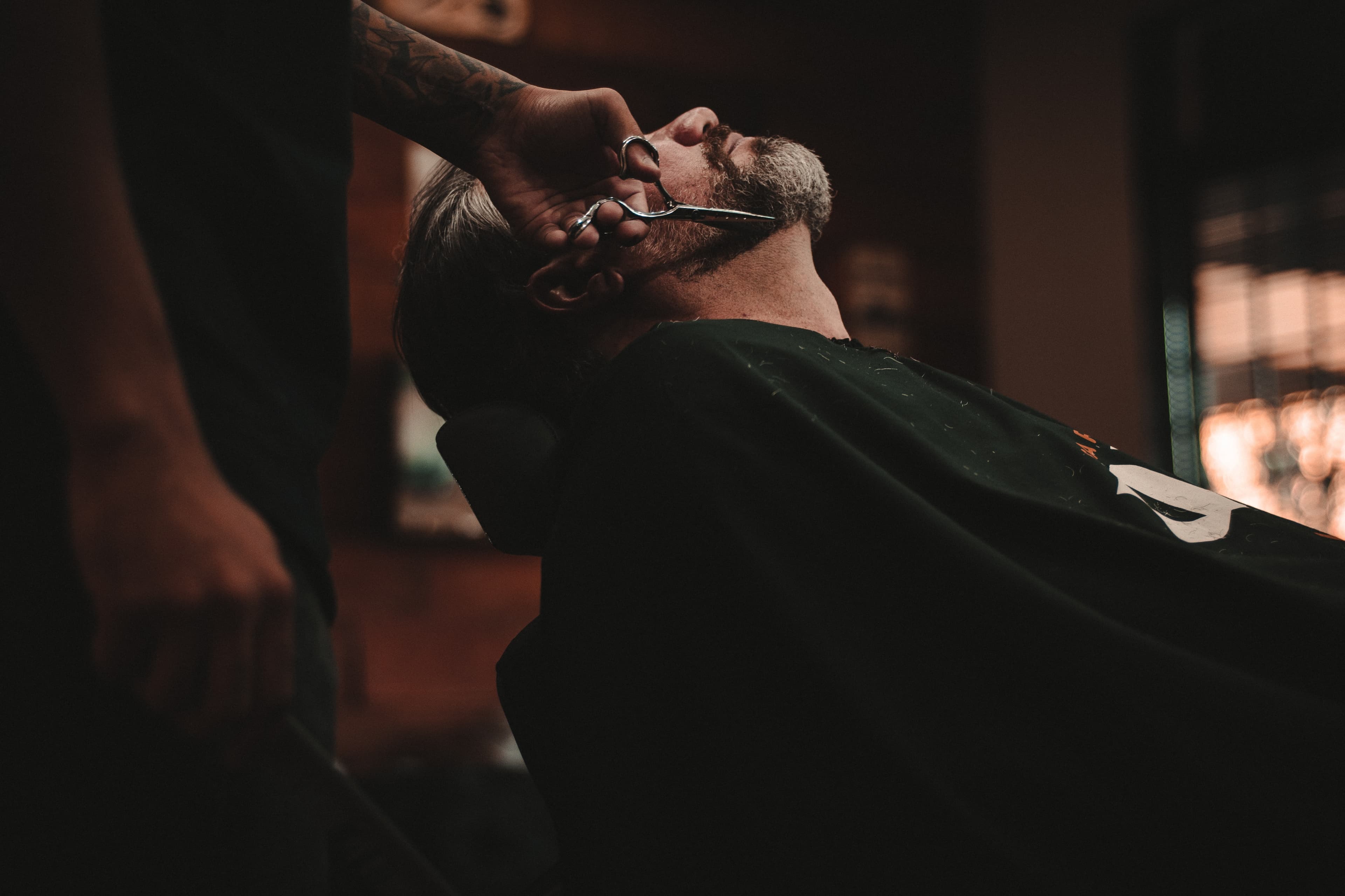 Imagem de um barbeiro cortando o cabelo de um cliente